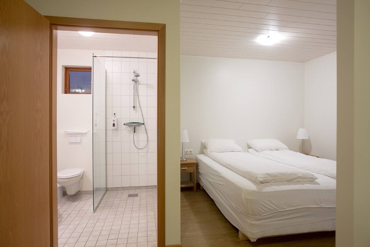 A bedroom with a bed, bedside table, and a nightstand.
