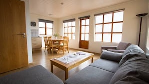 Ein Wohnzimmer mit einer Couch, einem Couchtisch und einem Essbereich mit Tisch und Stühlen.