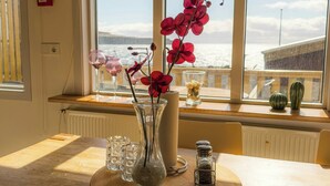 Ein Esstisch mit einer Blumenvase, zwei Weingläsern und Salz- und Pfefferstreuern.
