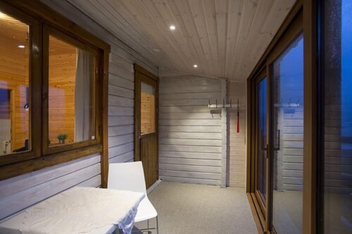 Una habitación con una mesa, sillas, una puerta de madera y una ventana.