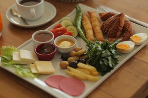 Un plato de desayuno con diversos alimentos como huevos, pan, verduras y salsas.