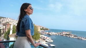 A person overlooking a marina with boats and a cityscape in the background. - Sinop Mola Otel (Sinop)