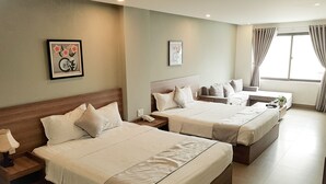 A hotel room with two beds, a bedside table with a lamp, a nightstand, and a window with curtains. - An Hoi Canary Hotel (Da Nang)