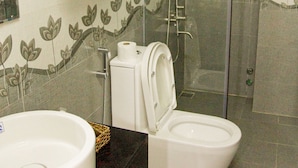 A bathroom with a glass-enclosed shower, a toilet, and a sink. - An Hoi Canary Hotel (Da Nang)