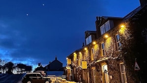 A historic building with ivy-covered walls and a sign indicating a hotel. - Aysgarth Falls Hotel (Leyburn)