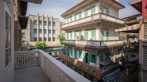 A multi-story building with balconies and a sign in a foreign language. - Nornyaowarat Hostel (Bangkok)
