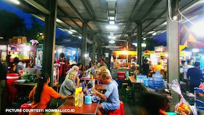 An indoor market with various stalls and people shopping. - Simon Homestay (Denpasar)