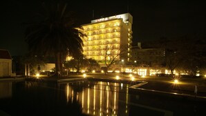 A multi-story hotel with a pool in the foreground. - Hotel Juraku (Ito)