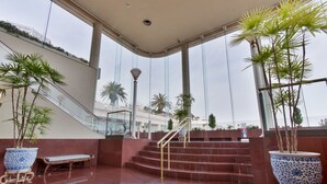 A spacious lobby with a marble floor, a staircase, and potted plants. - Hotel Juraku (Ito)