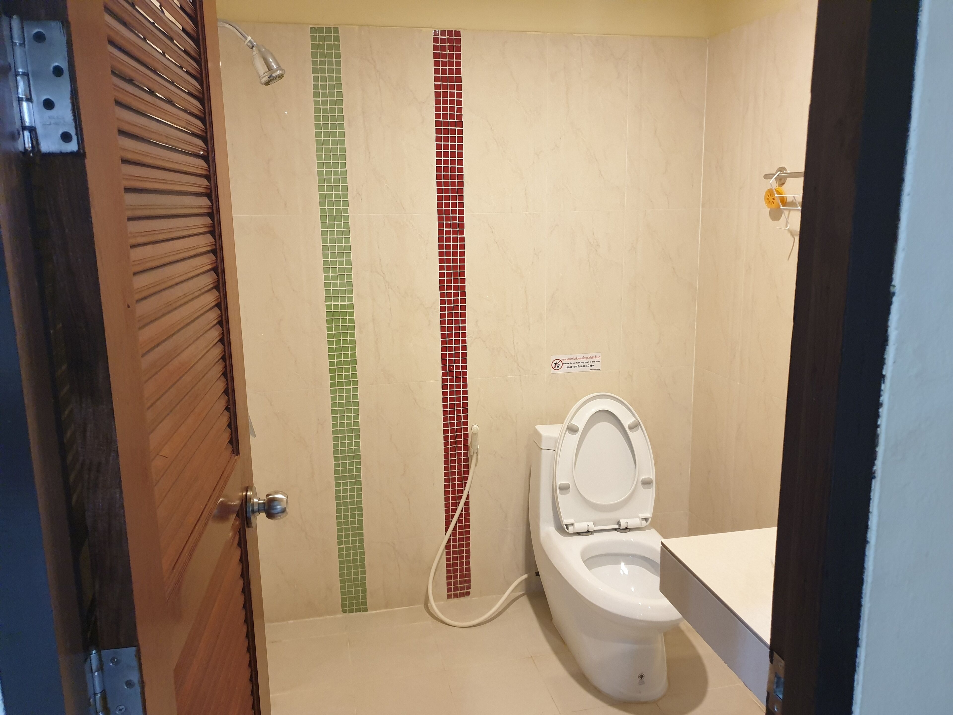 A bathroom with a toilet, a shower, and a sink.