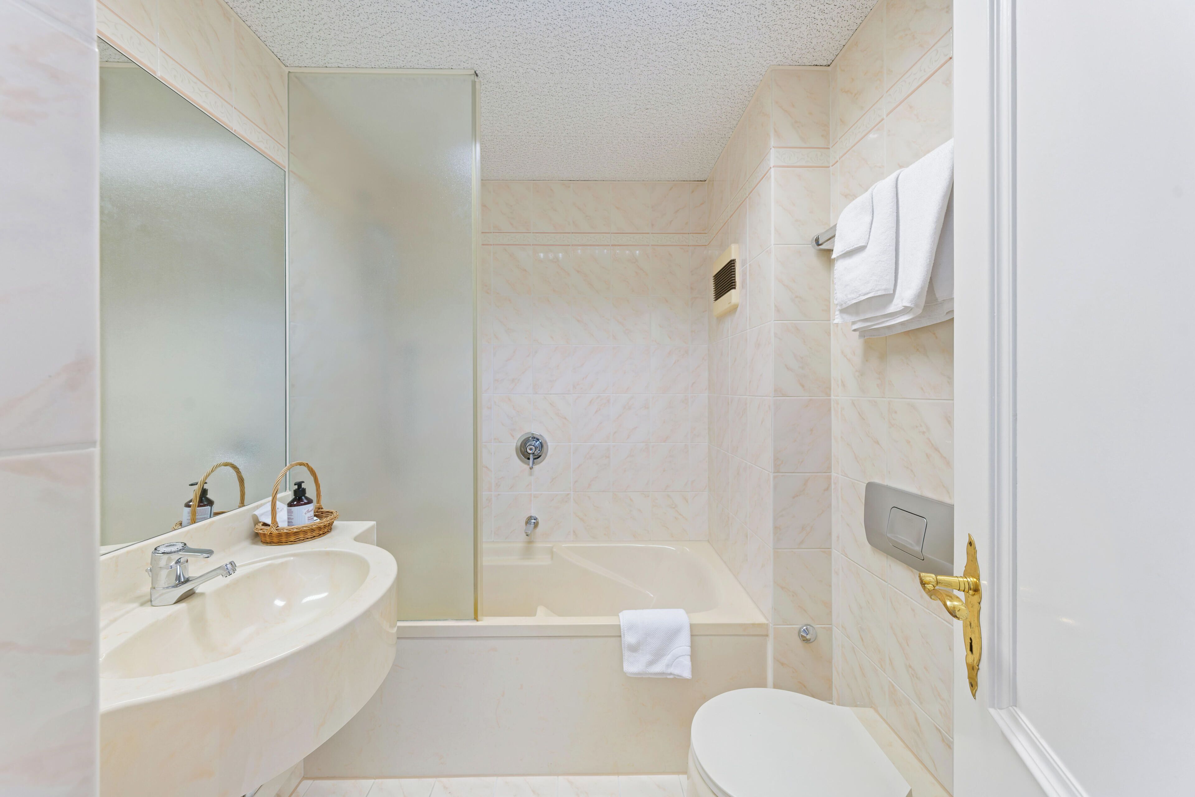 A bathroom with a bathtub, a toilet, and a sink.