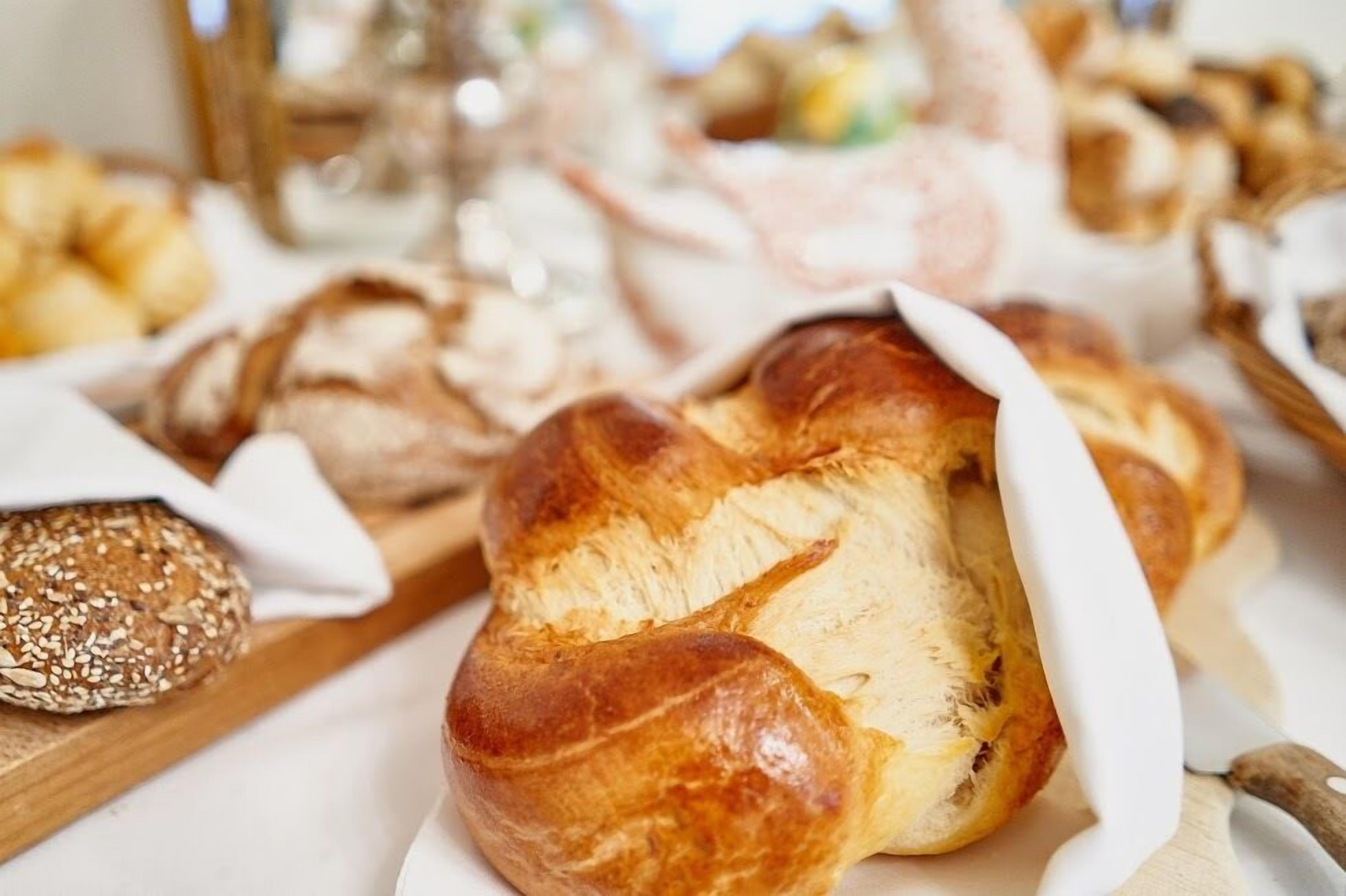A variety of breads and pastries on a wooden board.