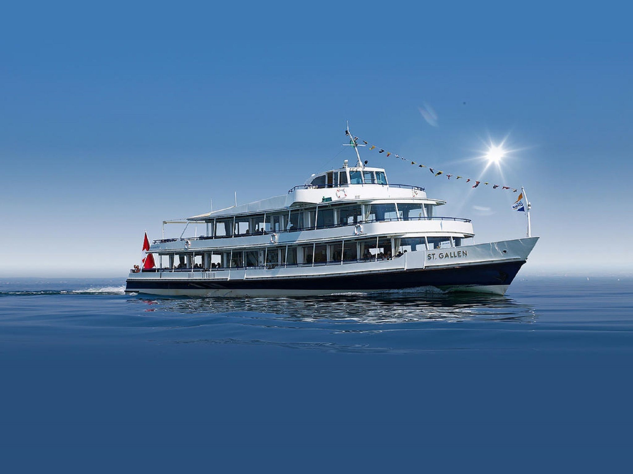 A large, multi-deck boat named "St. Gallen" with a prominent upper deck and a flag at the stern.