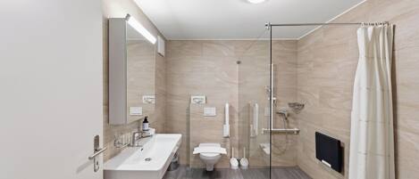 Un baño moderno con cabina de ducha de vidrio, lavamanos doble e inodoro.