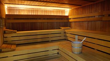 Una sauna de madera con bancos y un cubo.