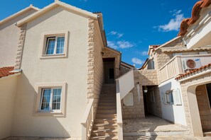 Une rue étroite avec un escalier menant à l’entrée d’un immeuble.