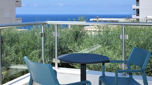 A balcony with a table and chairs, overlooking a coastal view. - Sunlight Breeze Villa (Chania)