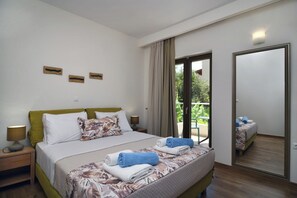 A bedroom with a bed, bedside tables, a mirror, and a balcony view. - Sunlight Breeze Villa (Chania)