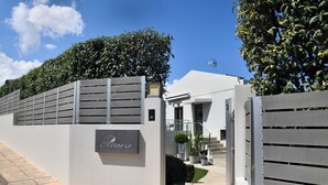 A modern building with a grey facade, a sign reading "Brise," and a gated entrance. - Sunlight Breeze Villa (Chania)