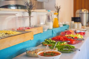 A buffet table with various food items and condiments.