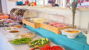 Un bufé con diversas opciones de comida, incluyendo verduras, carnes y ensaladas.