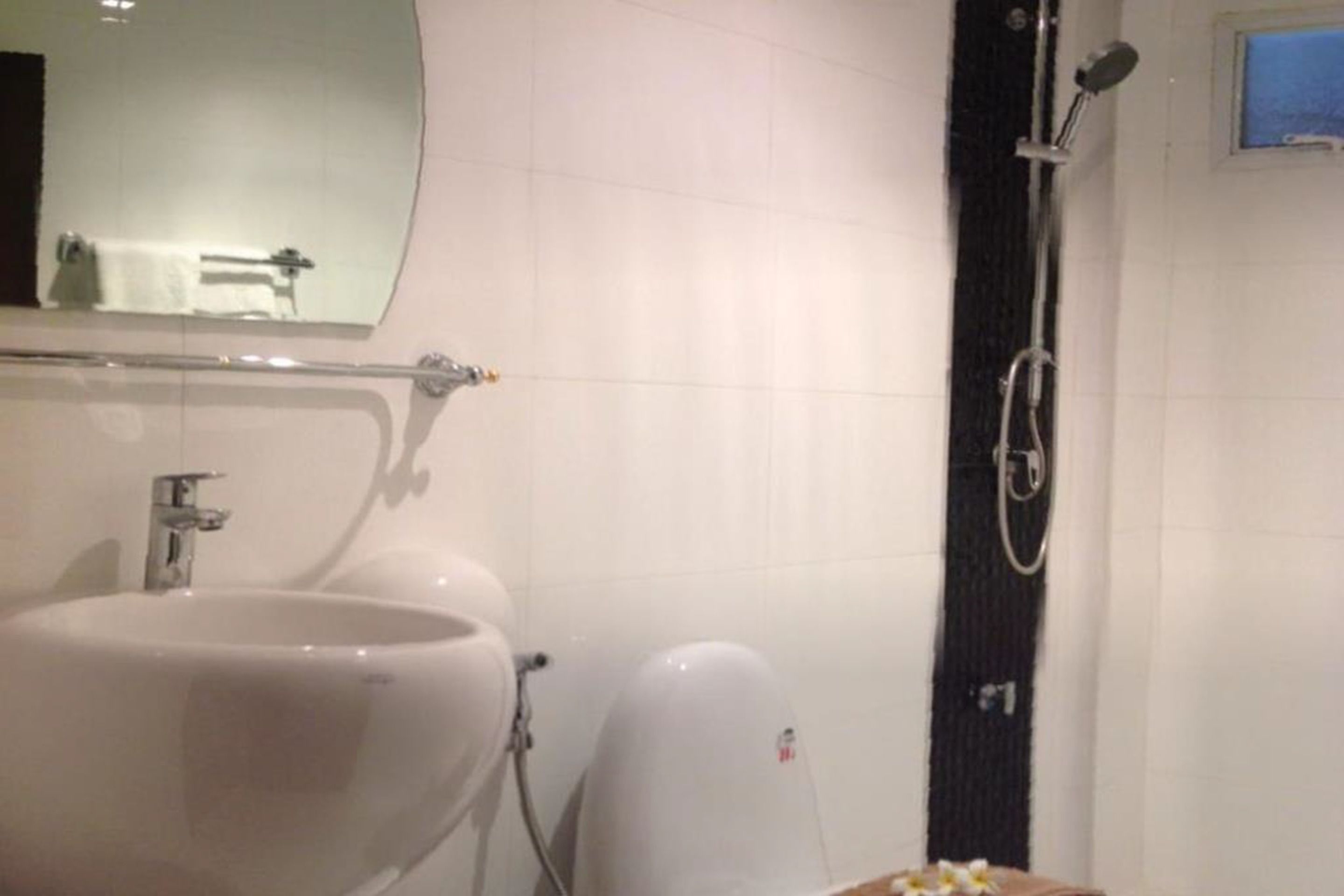 Un baño con lavamanos, espejo y ducha.