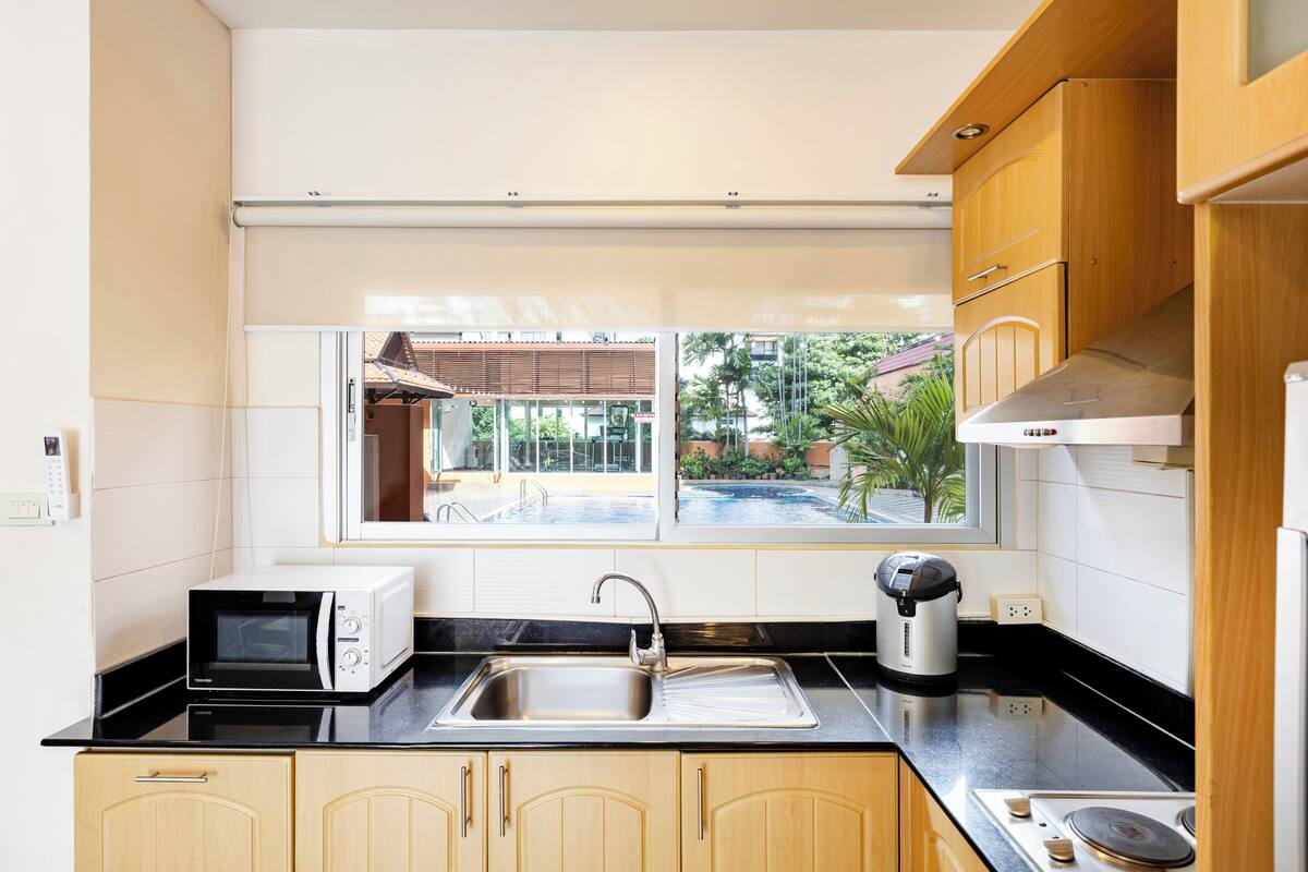 A modern kitchen with a built-in microwave, a sink, and a coffee maker.