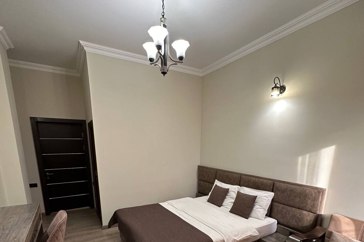 Un dormitorio con cama, sofá, escritorio y armario.