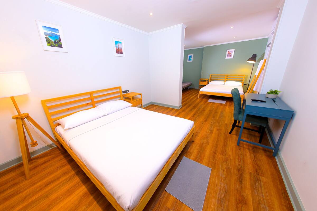 Une chambre d’hôtel avec un grand lit, un bureau avec une chaise, une lampe et deux petites tables de chevet.