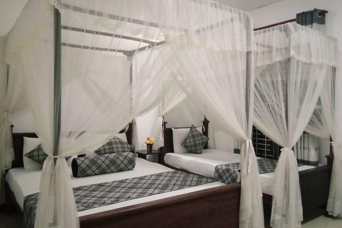 Quarto com uma cama de dossel, uma mesa de cabeceira e um criado-mudo.