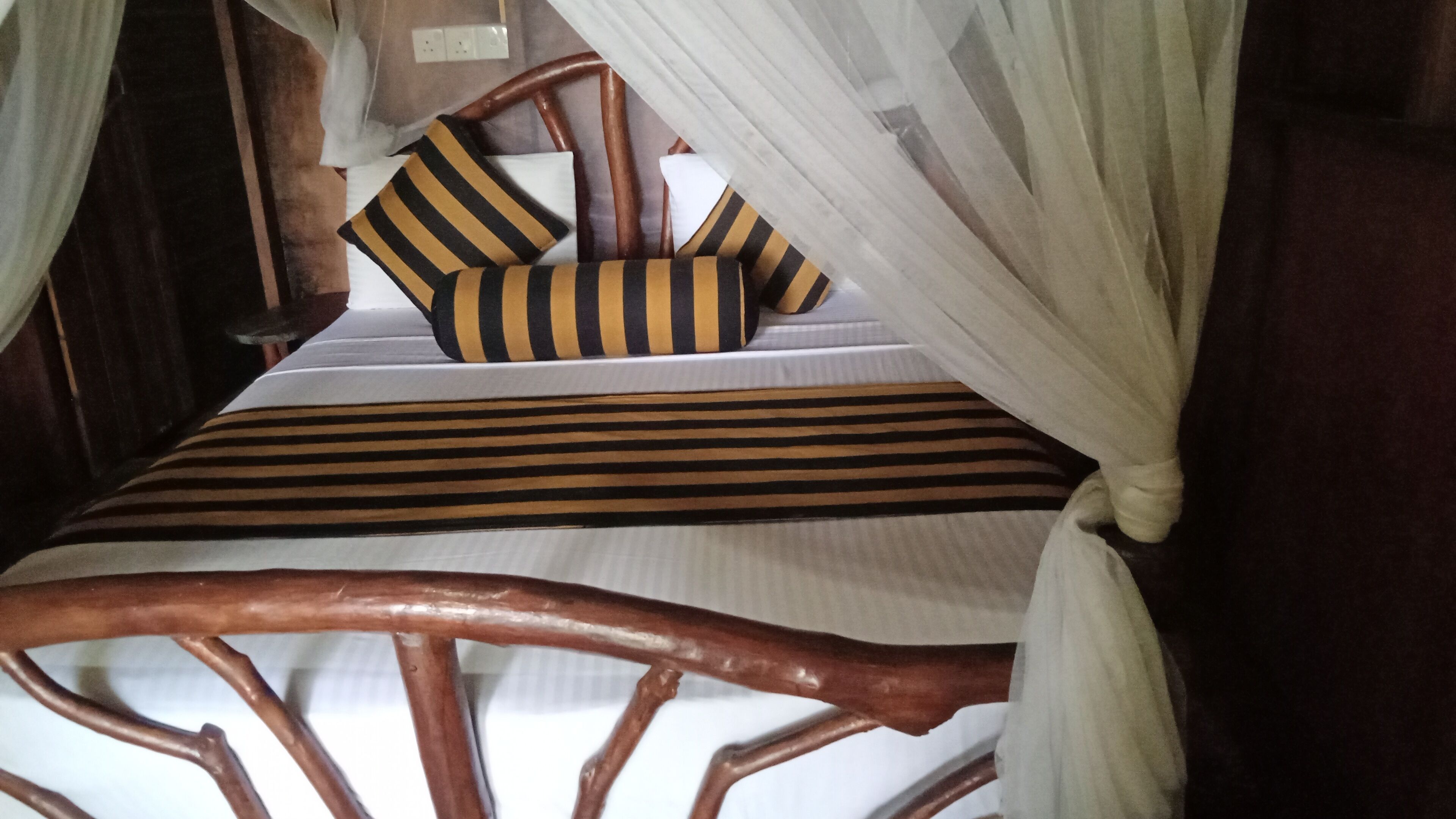 A bed with striped bedding and a canopy.
