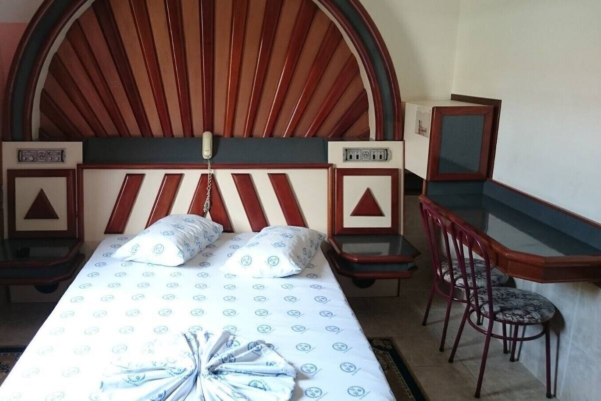 Une chambre à coucher avec un lit, des tables de chevet, un bureau et une chaise.