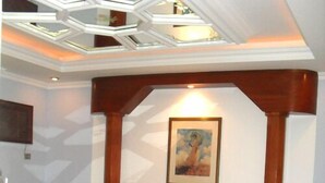 Une chambre à coucher avec un lit en bois, une tête de lit, une table de chevet, un tableau encadré au mur et un escalier.