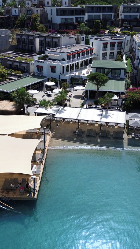 A coastal hotel with a rooftop bar, outdoor seating, and a pool area.