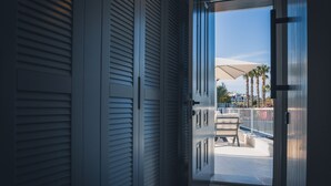 A view through a door into a balcony area with a white chair and an umbrella. - Casamia Boutique Hotel (Bodrum)
