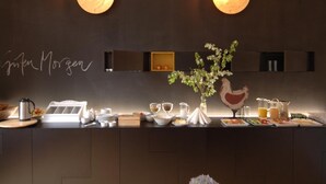 Een moderne keuken met twee hanglampen, een ontbijtbalk en een sierplant.
