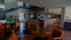 A modern indoor space with a bar area, seating arrangements, and a staircase. - Alsóörs Marina Hotel (Alsoors)