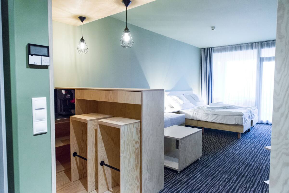 Una habitación de hotel moderna con cama, escritorio y armario.