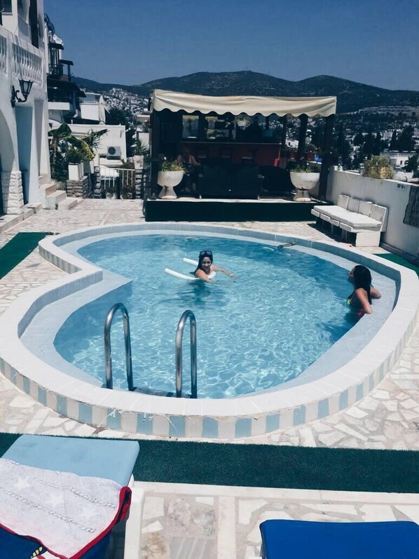 Utomhuspool, parasoller och solstolar