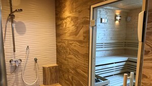 Un bagno moderno con una parete in legno, un box doccia in vetro e una panca integrata.