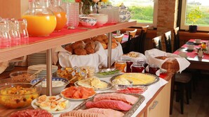 Un buffet con un'ampia scelta di cibi, tra cui frutta, formaggi, salumi e dolci.