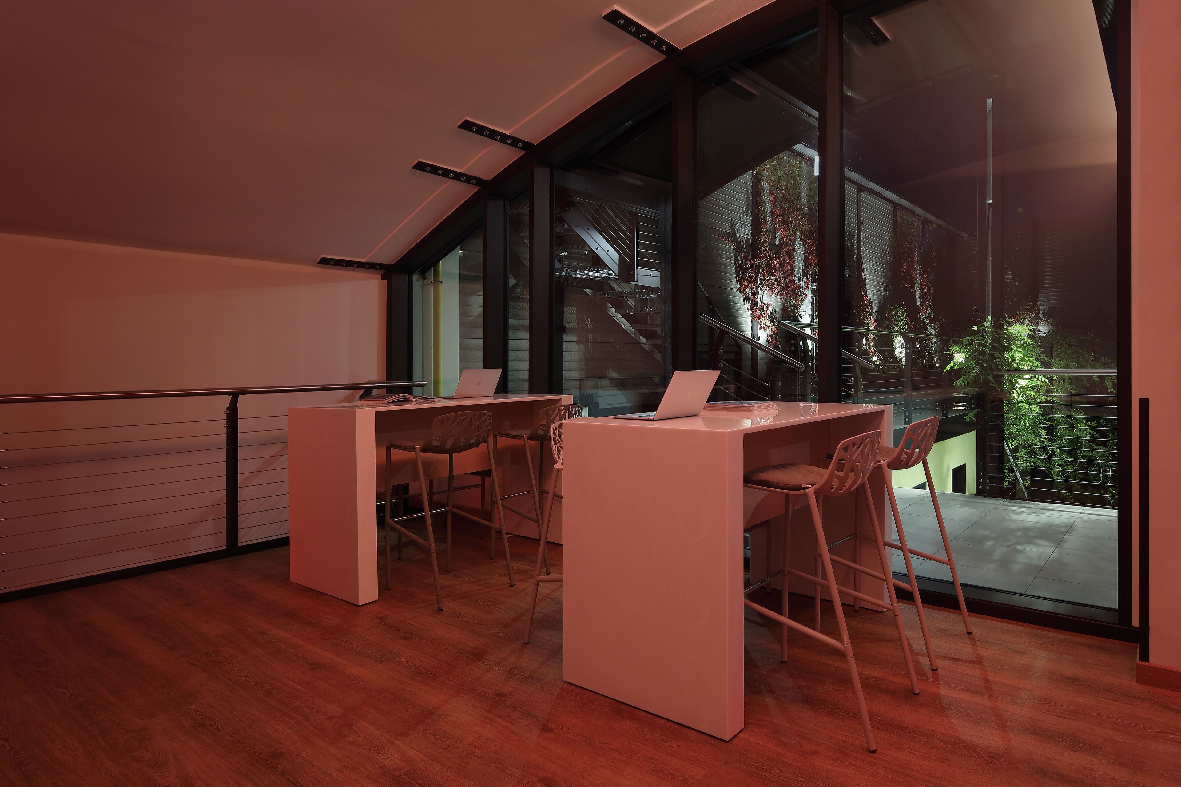 A modern office space with a large window, a desk, and two chairs.