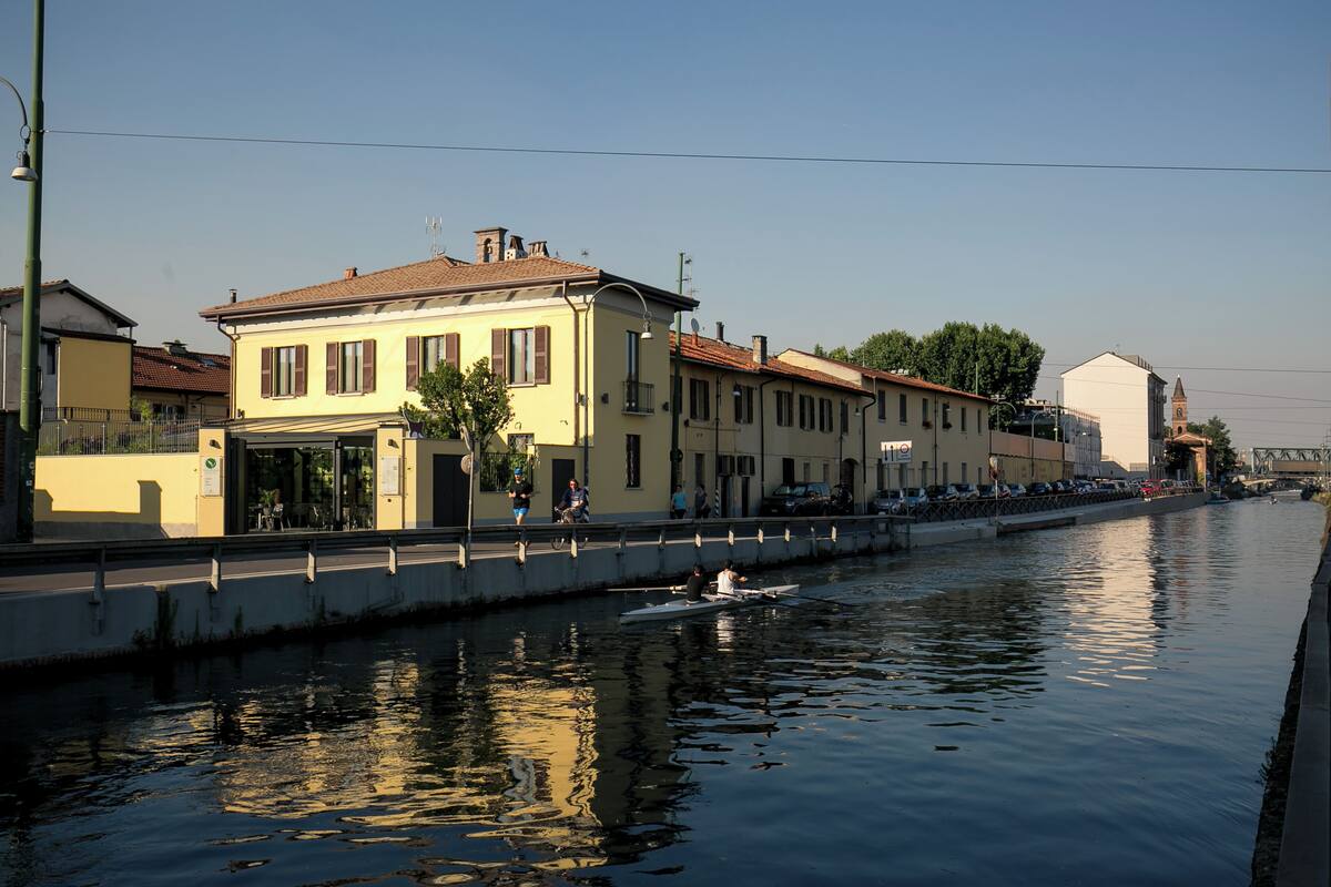 A canal with buildings on one side and a boat on the water.