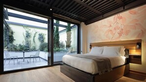 A modern bedroom with a large bed, a glass door leading to a balcony, and a floral wall mural. - Versoverde Alzaia Naviglio Grande (Milan)