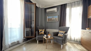 A modern living room with two grey armchairs, a coffee table, and a painting on the wall. - Flats Company - Karakoy Apartment (Istanbul)