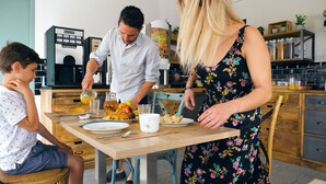 A family dining at a kitchen counter with a coffee machine, fruit, and pastries. - Hotel du Trégor (Treguier)