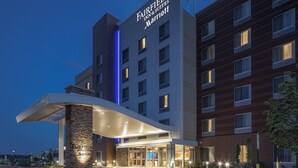 Un hotel Fairfield Inn & Suites Marriott de diseño moderno, con una entrada destacada y un pilar de piedra.