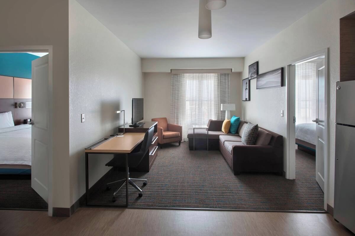 Une chambre d’hôtel avec un lit, un bureau, un canapé et une petite table.