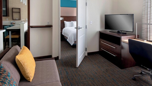 Une chambre d’hôtel avec un lit, une télévision, un bureau et un canapé.