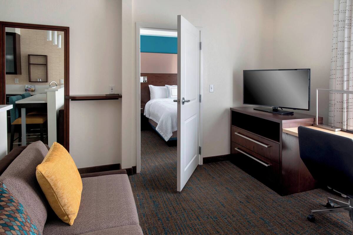 Une chambre d’hôtel avec un lit, une télévision, un bureau et un canapé.